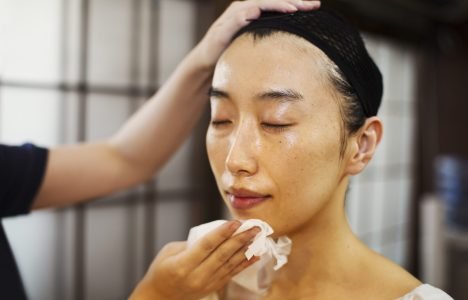 A geisha or maiko with a hair and make up artist creating the traditional hair style and make up preparing her face. ,Modern Geisha,Japan A geisha or maiko with a hair and make up artist creating the traditional hair style and make up preparing her face.