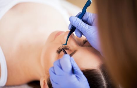 Eyelashes extensions. Fake Eyelashes. Eyelash Extension Procedure. Professional stylist lengthening female lashes. Master and a client in a beauty salon Eyelashes extensions. Fake Eyelashes. Eyelash Extension Procedure. Professional stylist lengthening female lashes. Master and a client in a beauty salon.